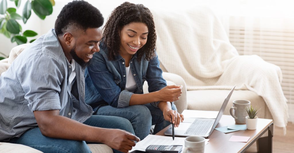 Couple calculating their DTI ratio on their couch