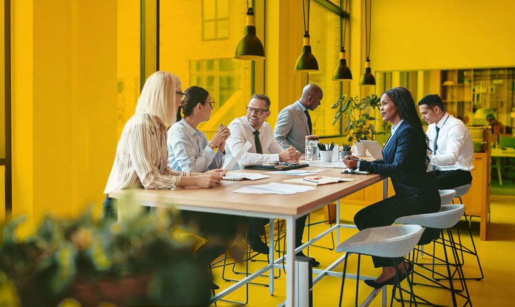 Team of Synergy One workers with an Orange background