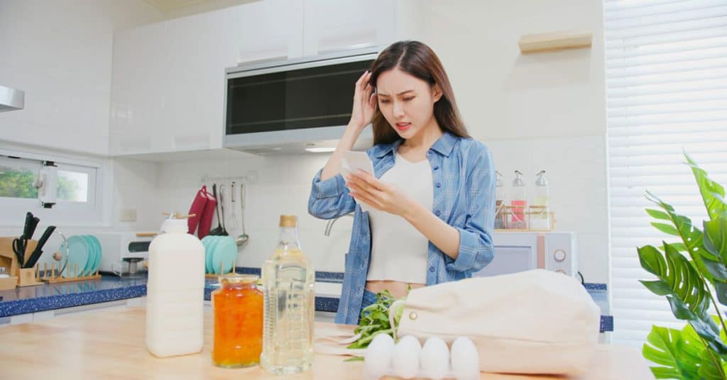 Surprised girl reading the Vietnamese news story of real-estate fraud