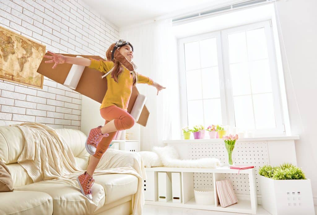 Girl in home with play wings on
